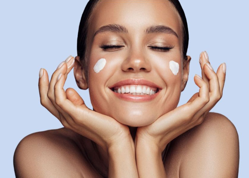 Woman smiling with eyes closed, gently cupping her face and wearing a natural moisturiser – representing the nourishing benefits of Tamera E3 Light Crème.