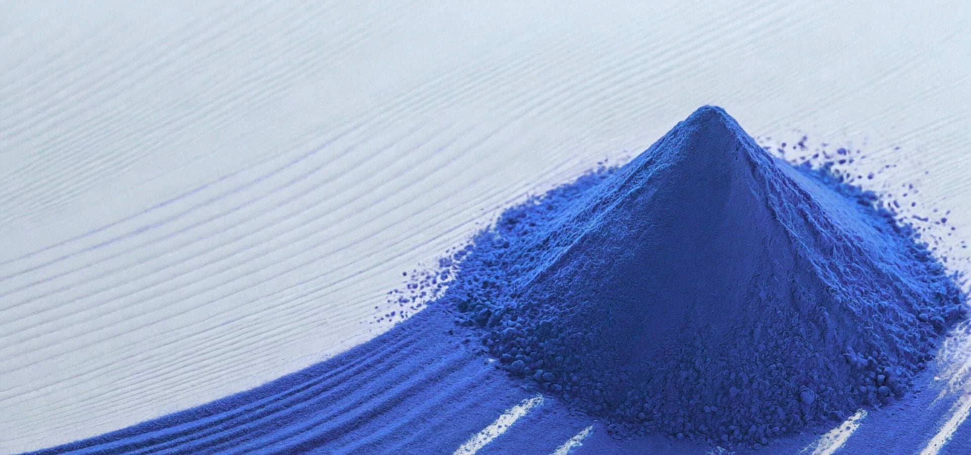 BlueMAJIK powder forming a small mountain on a light blue background