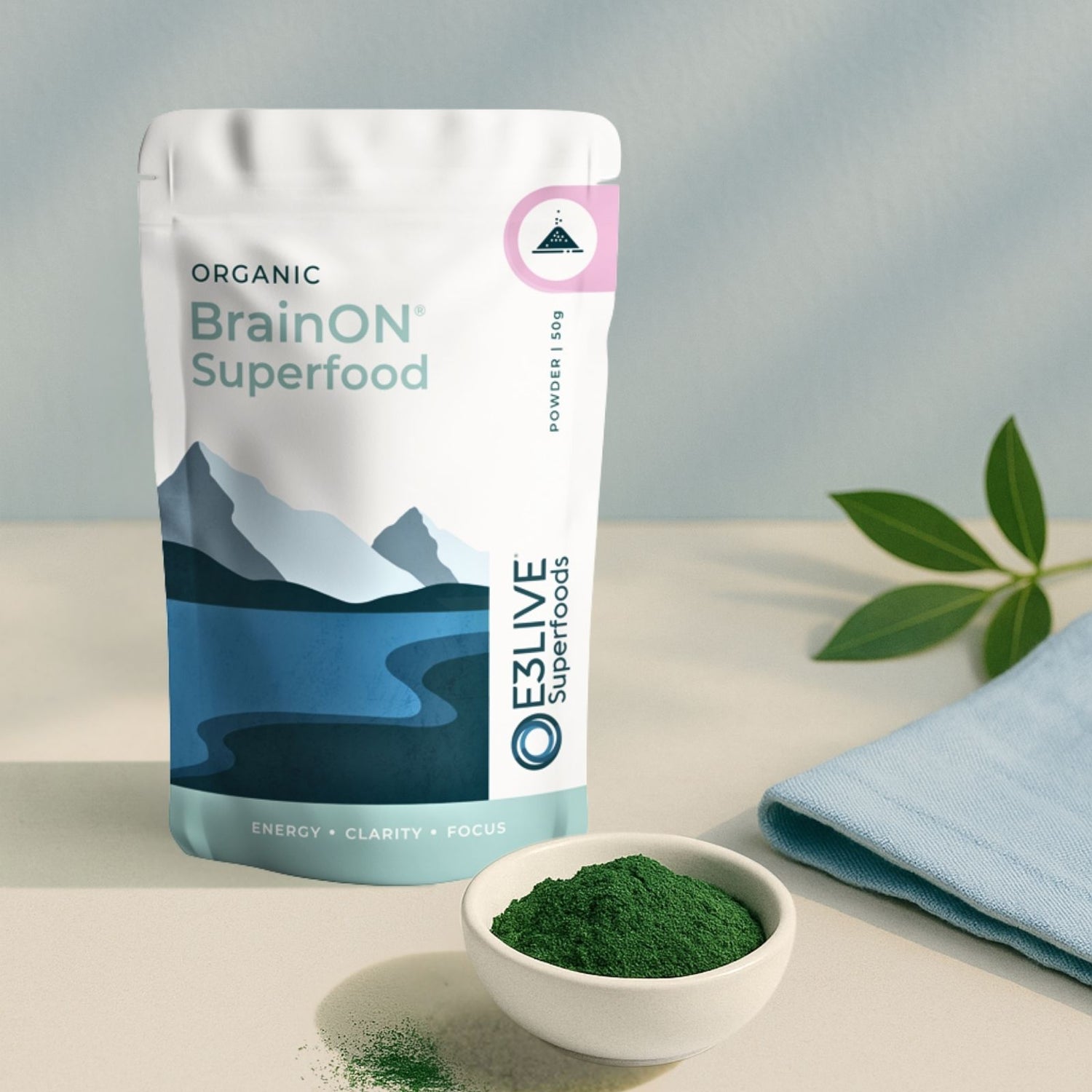 BrainON Superfood package by E3LIVE with a bowl of green powder on a light surface.