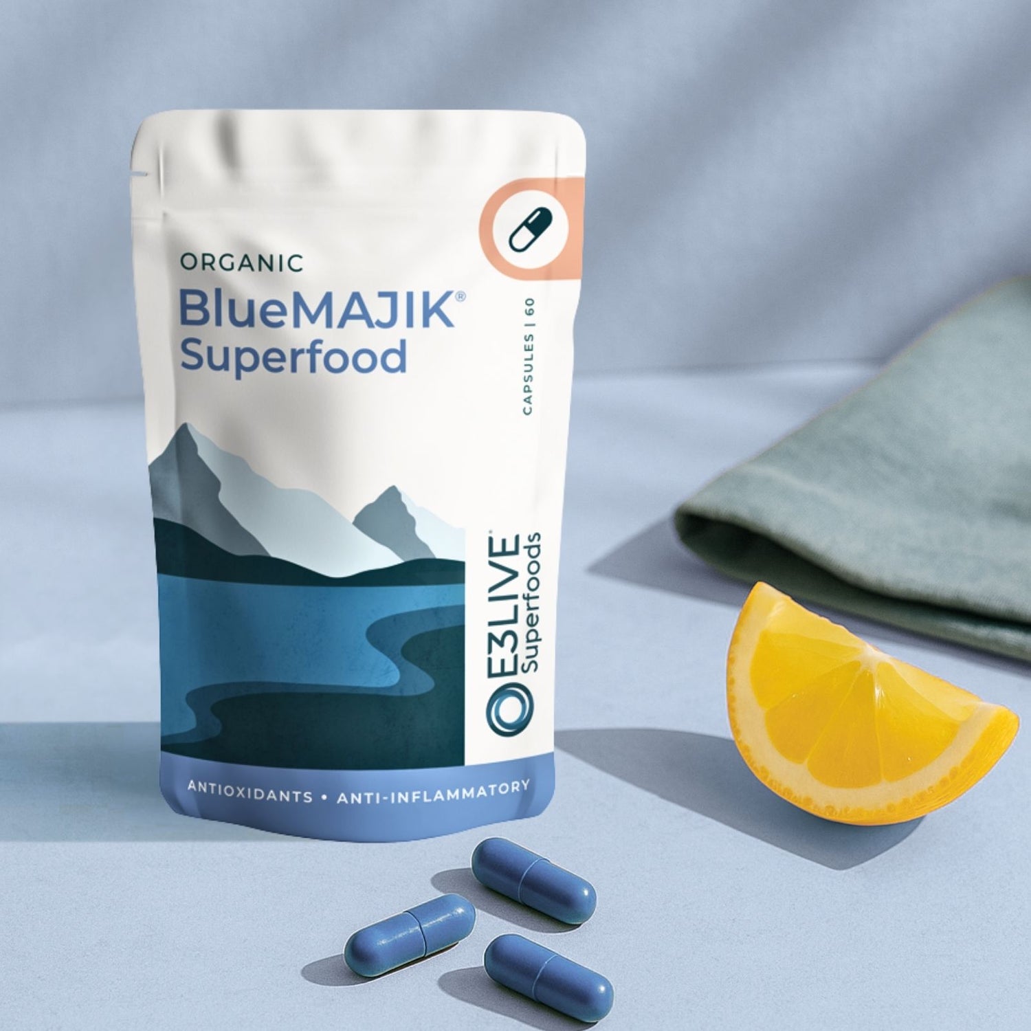 BlueMAJIK Superfood package with capsules and a lemon wedge on a light blue background