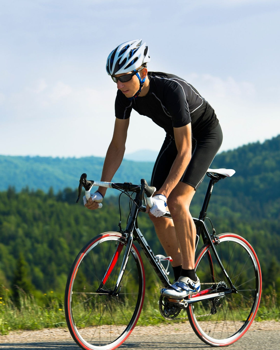 Cyclist riding on a road with mountains in the background