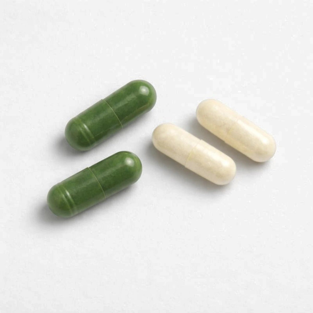 Two E3AFA capsules and a E3Probiotics  Gut Rescue Capsules and an E3Enzymes Supreme Capsule on a light background.
