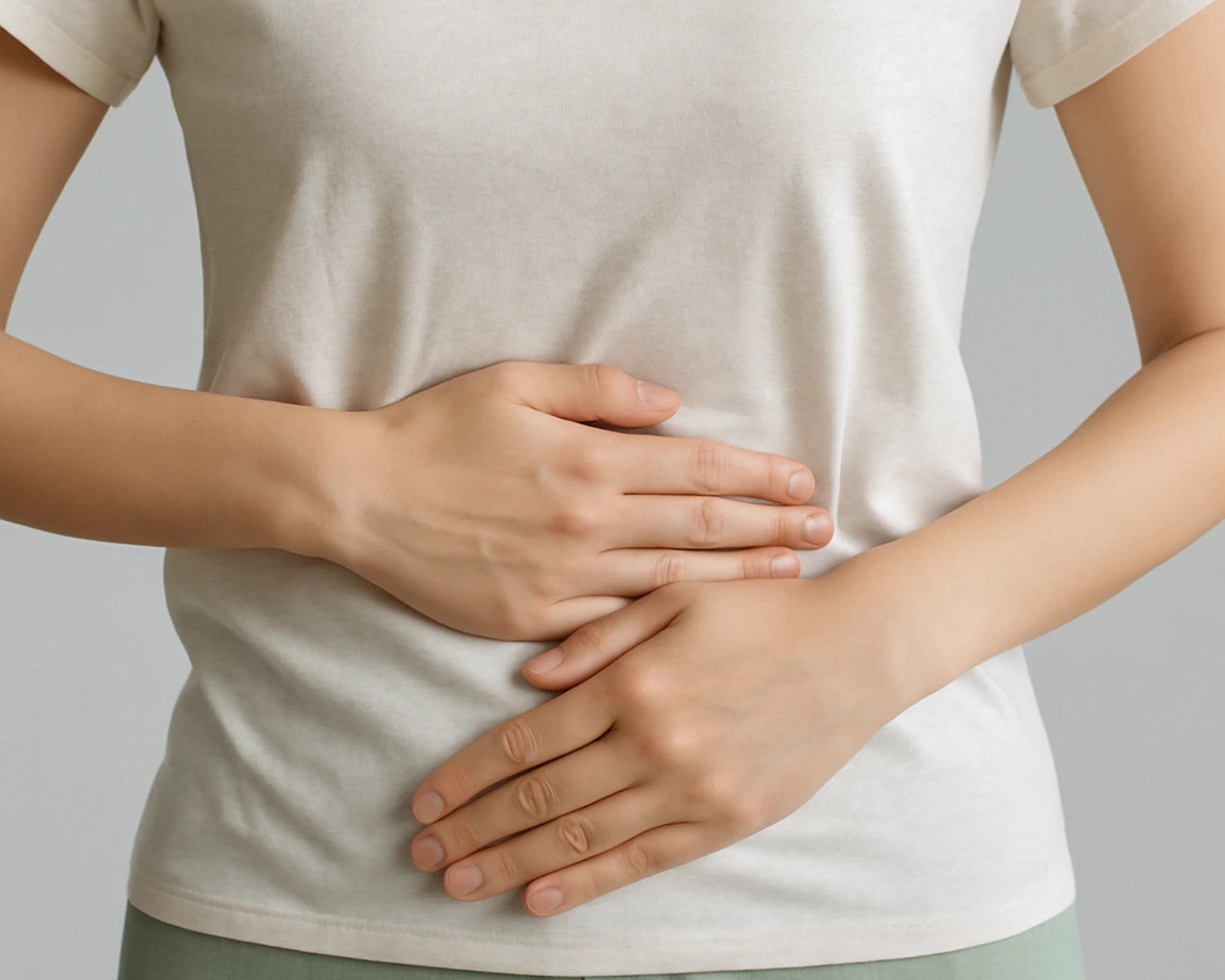 Person wearing a white t-shirt with hands on a gray background