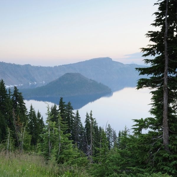 Lake surrounded by mountains and trees with a clear sky at Klamath Falls