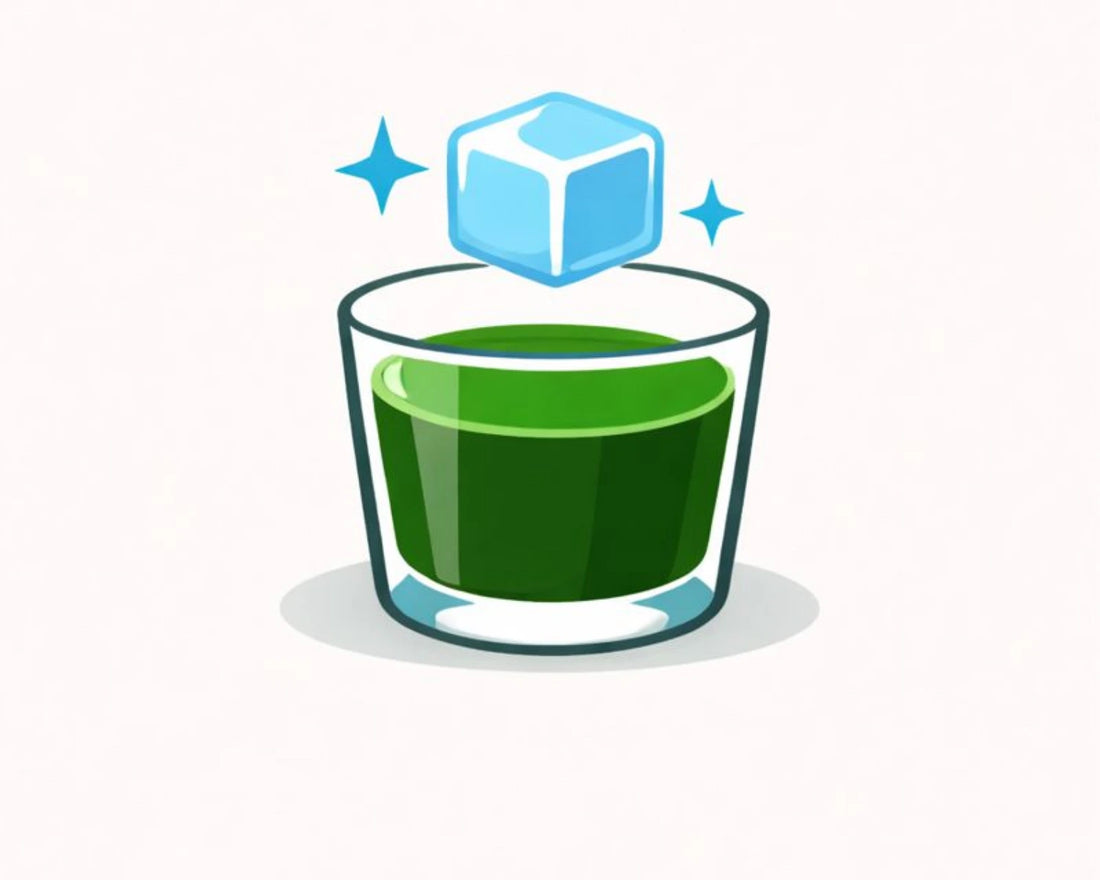 Glass of green liquid with a floating ice cube on a white background