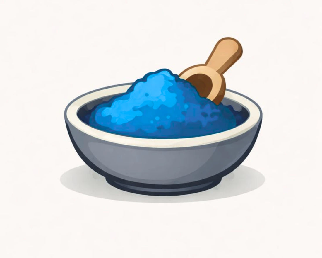 Blue ice cream in a bowl with a wooden spoon on a white background