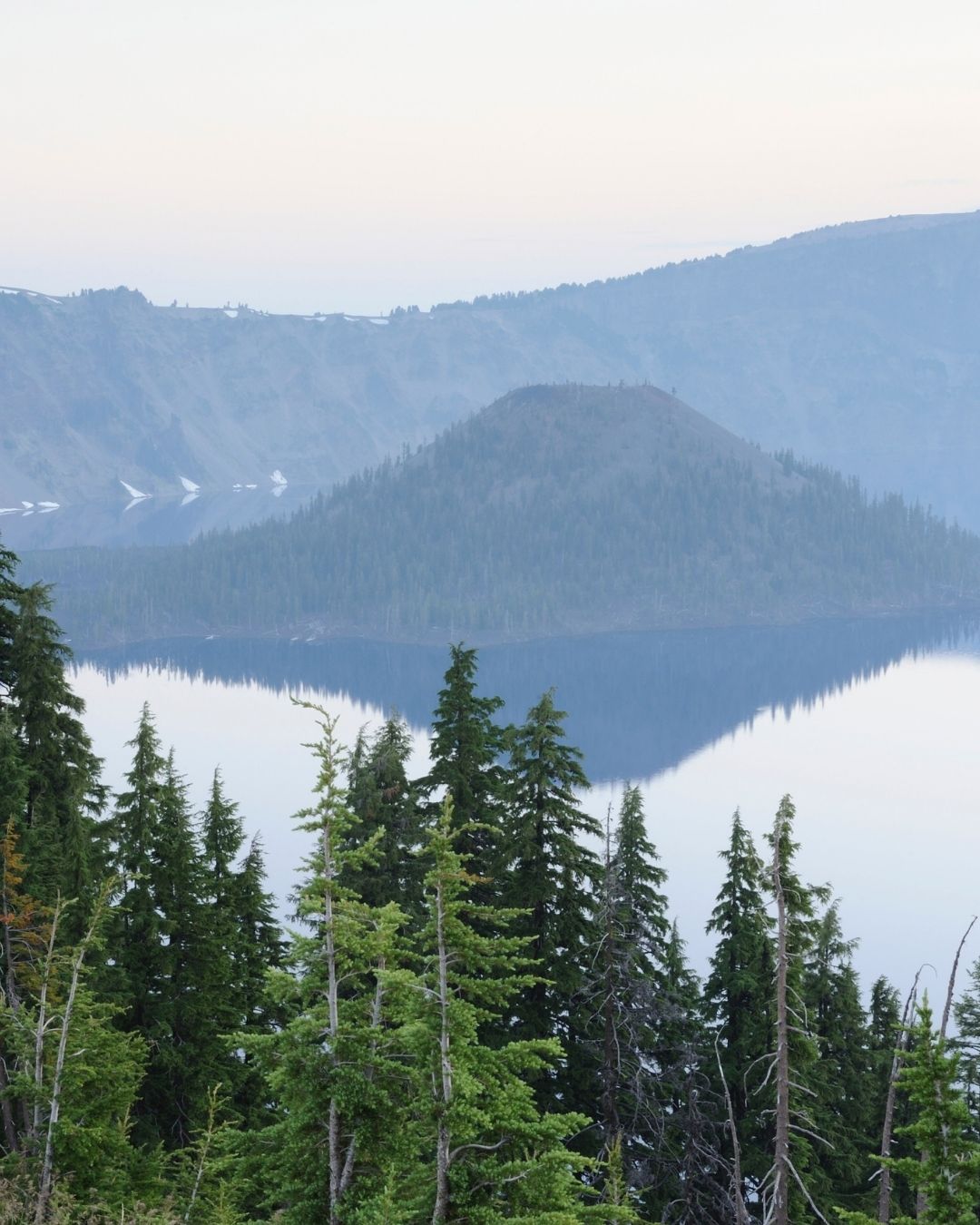 Upper Klamath Lake - Mountain landscape with trees and a lake, reflecting the surrounding scenery.