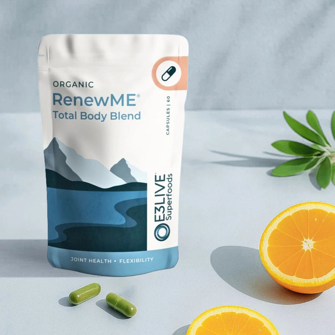 Packaging of Organic RenewME Total Body Blend by E3LIVE Superfoods with oranges and capsules on a light gray background