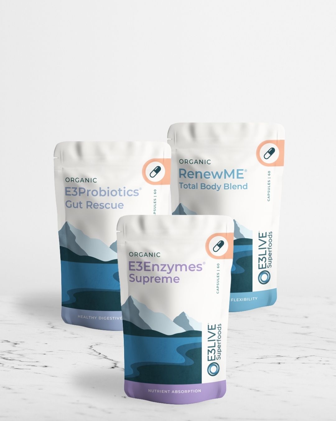 Three packages of E3Probiotics Gut Rescue,  E3Enzymes Supreme and RenewME Total Body Blend on a white marble background