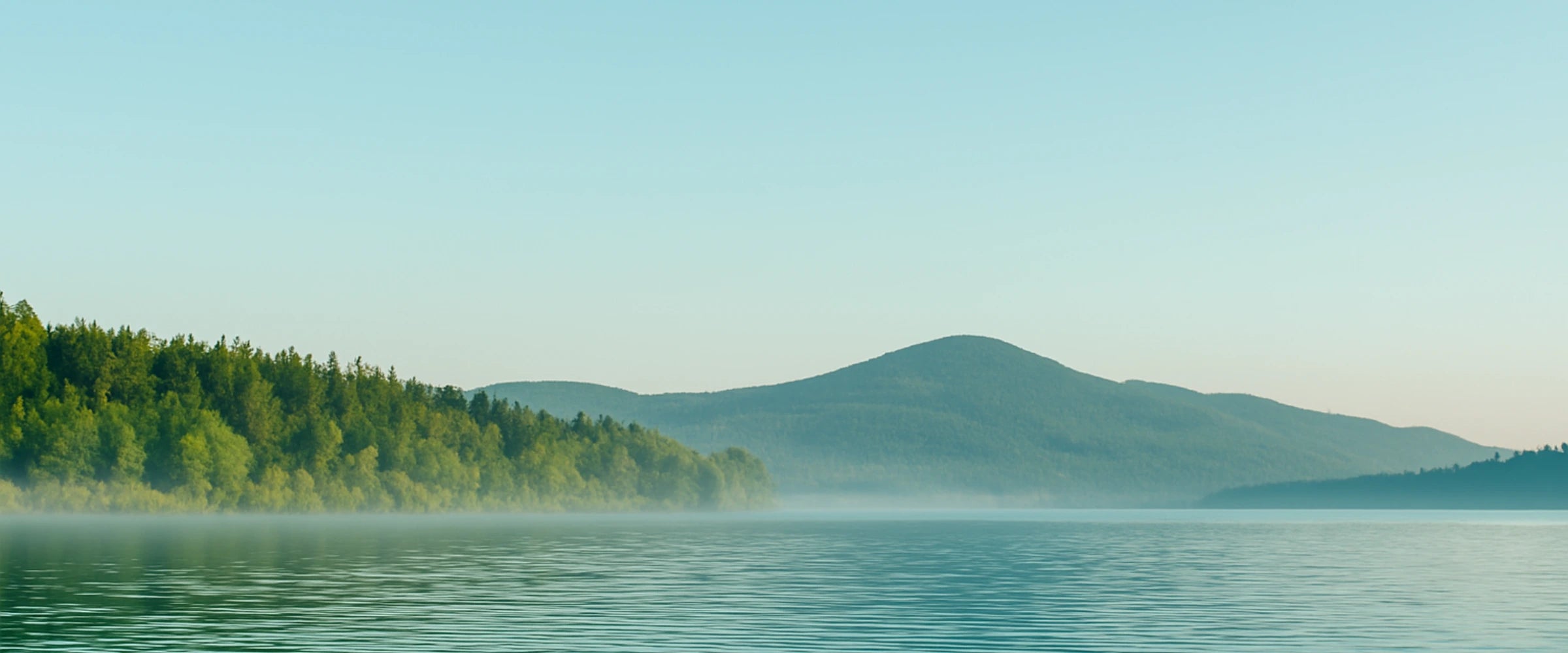 Upper Klamath Lake with mist and trees on a clear day