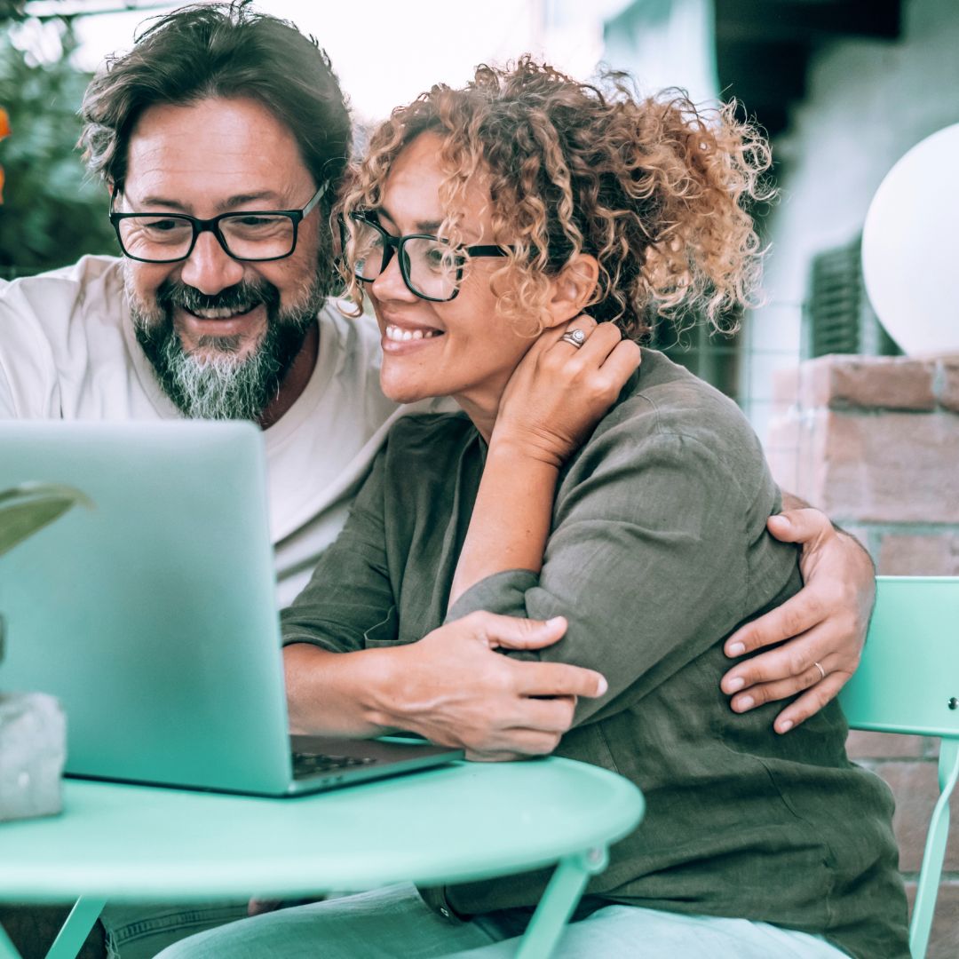 A focused man and woman working on a laptop outdoors, surrounded by greenery, representing mental clarity and productivity.