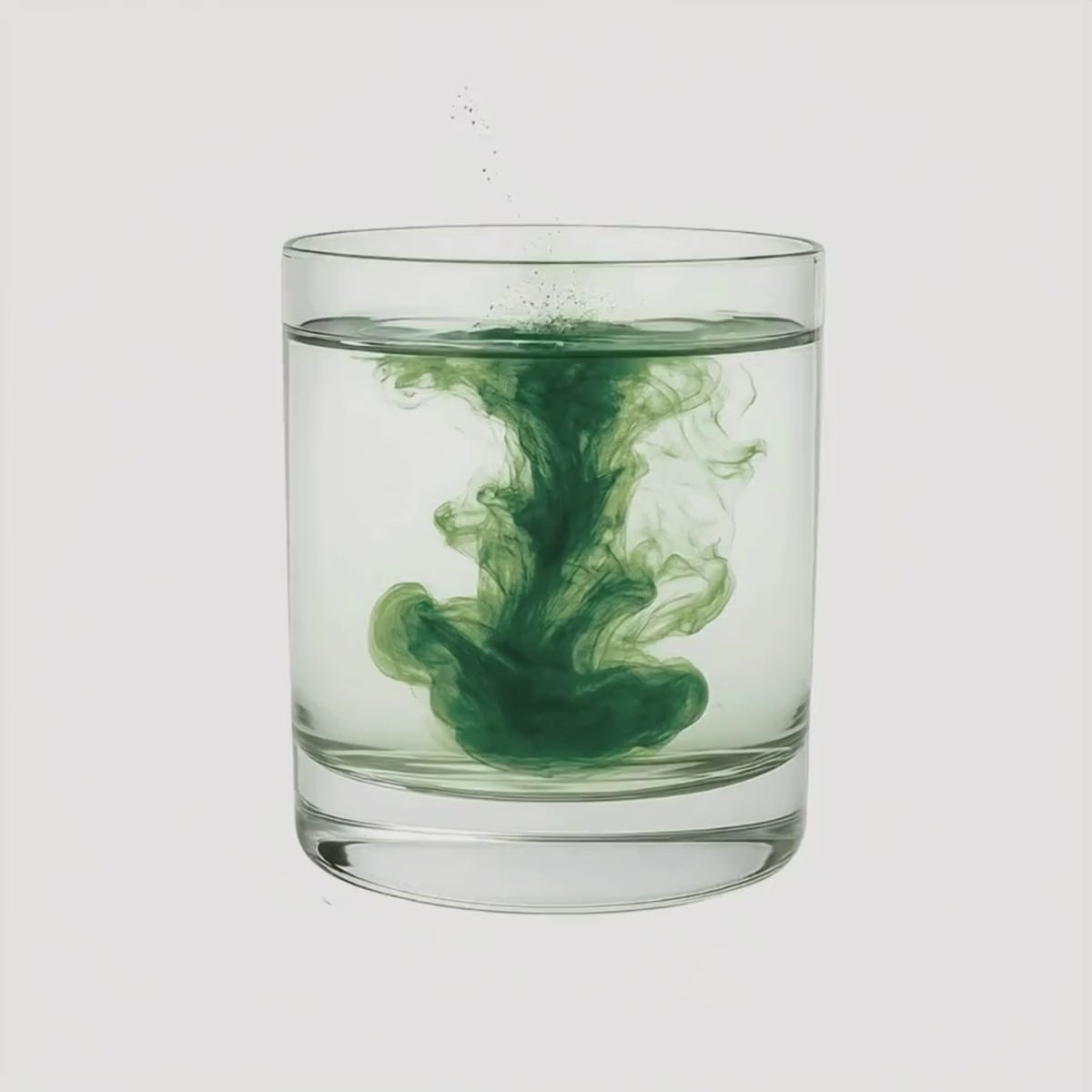 Load video: Green AFA powder swirling in a glass of water.